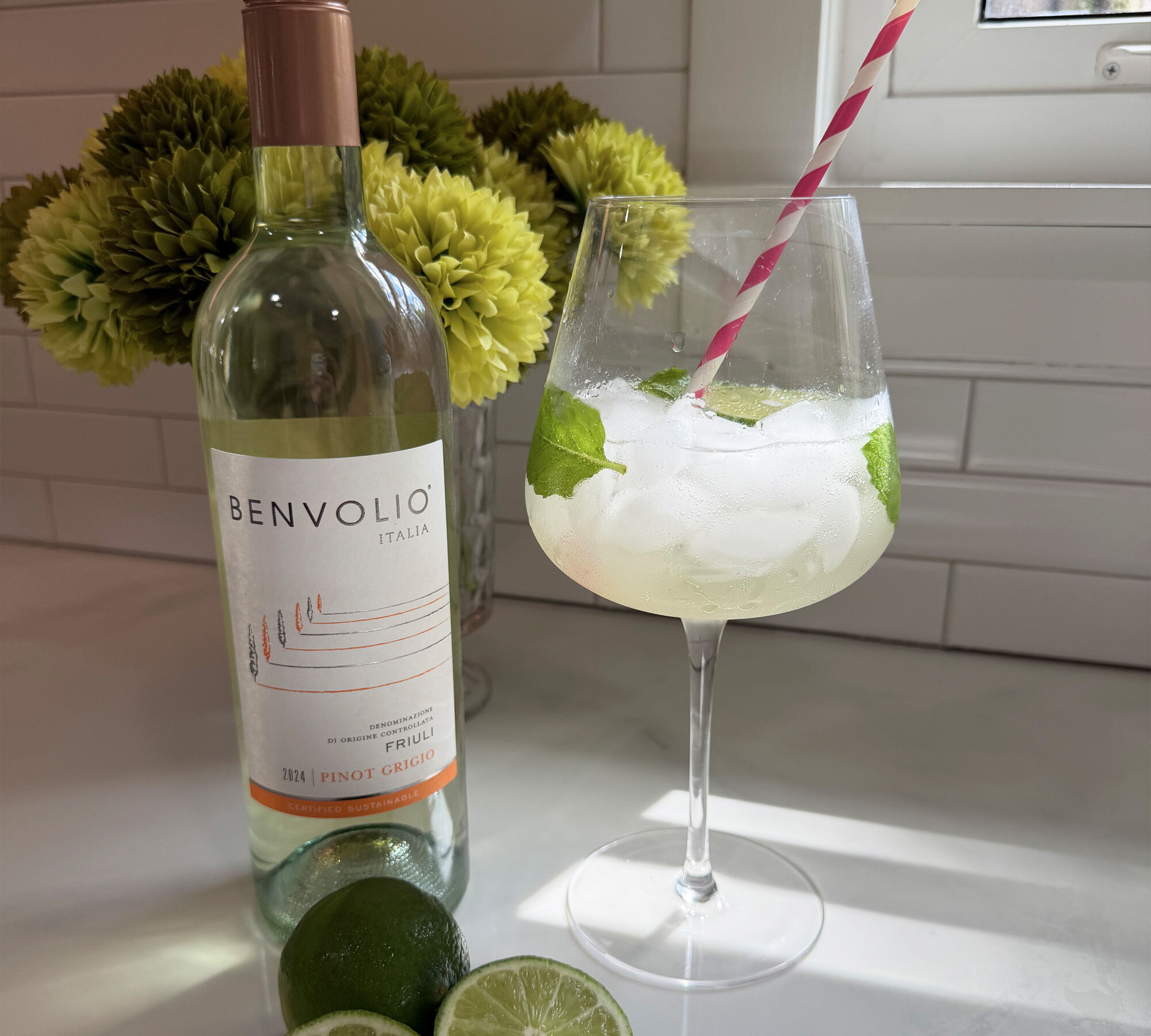 A bottle of Benvolio Pinot Grigio with a hugo spritz cocktail in a wine glass
